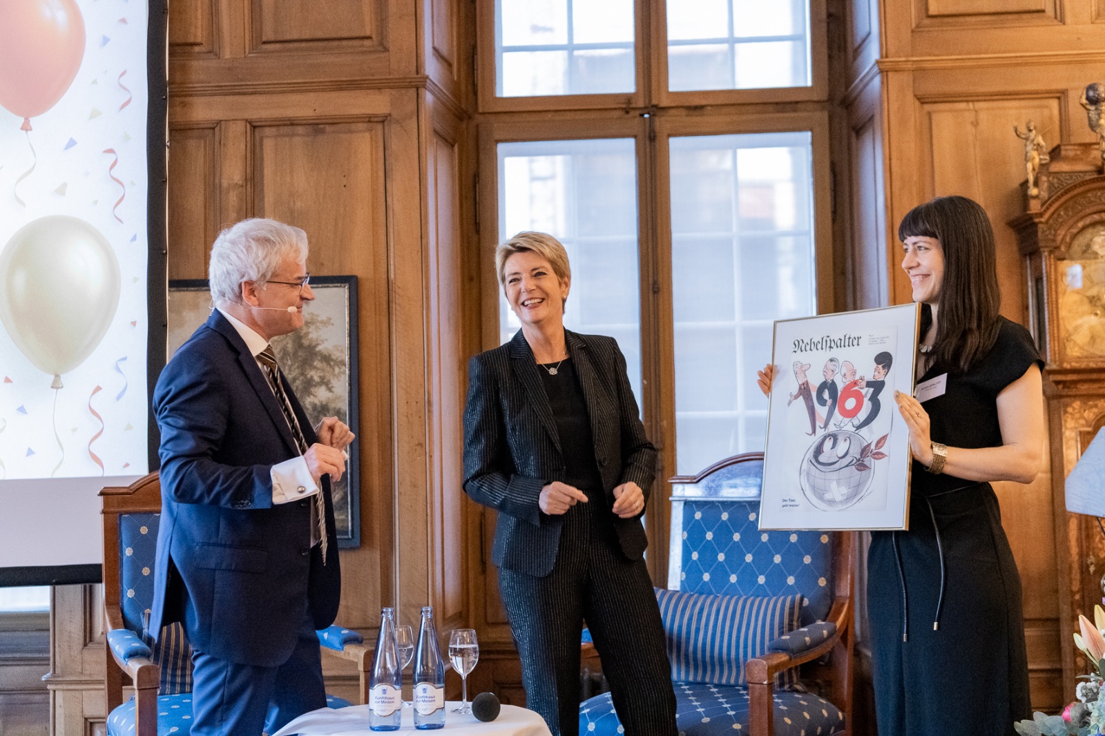 Als Geschenk erhielt Bundespräsidentin Karin Keller-Sutter ein passendes Nebelspalter-Cover aus ihrem Geburtsjahr 1963 überreicht. «Der Tanz geht weiter», titelte der Nebelspalter damals – und zeigte die Präsidenten der Weltmächte beim Hüftschwung. Bild: Tabea Vogel