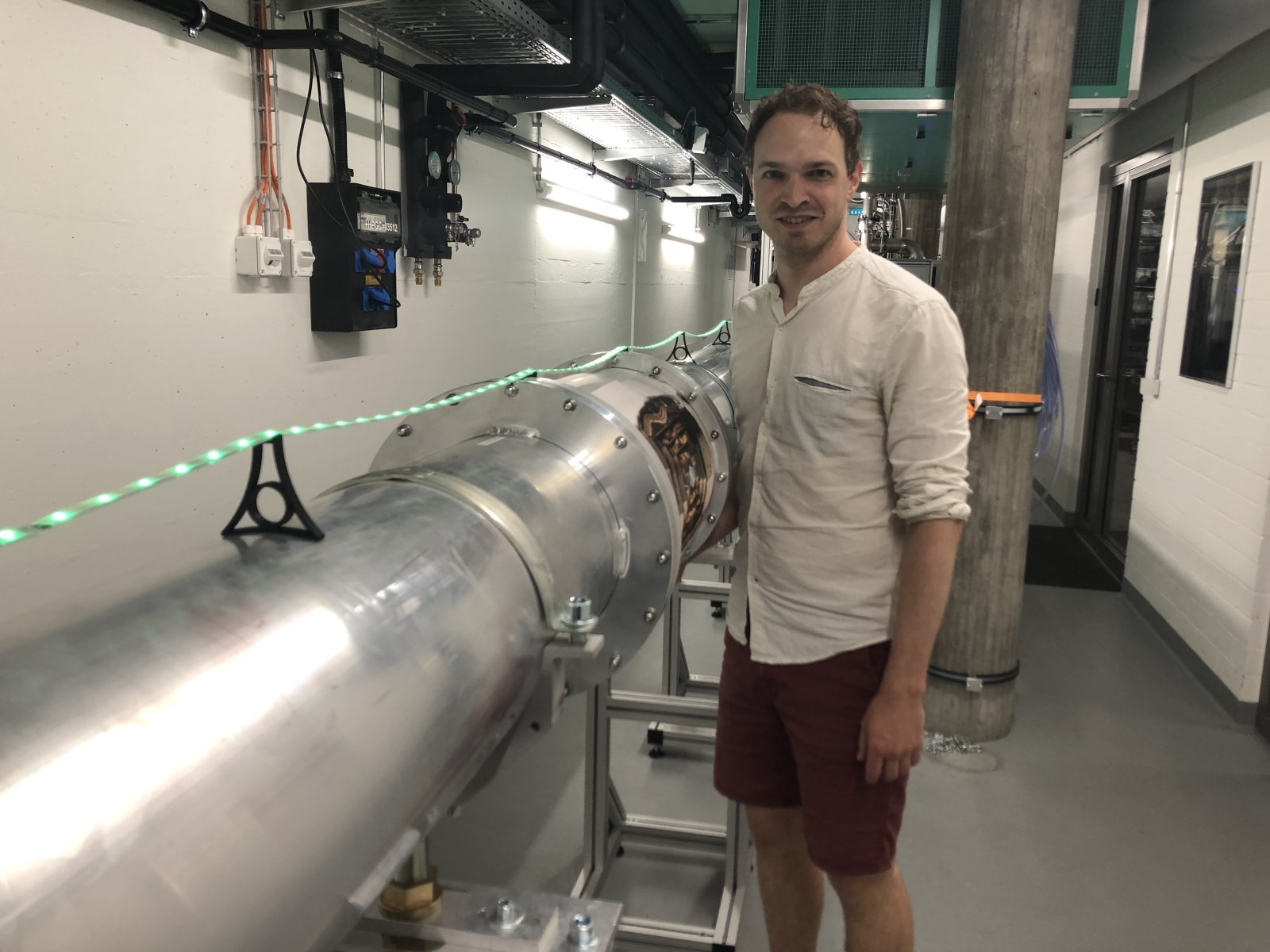 Millionenfach wiederholte Experimente: Physiker Simon Storz vor der 30-Meter-Röhre auf dem Hönggerberg. Bild: Reichmuth