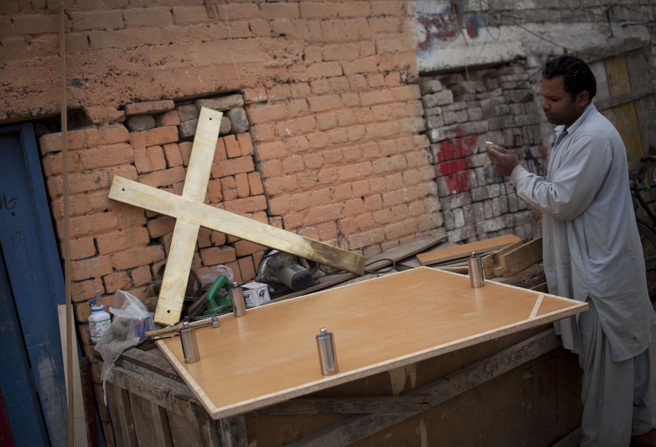 Ein pakistanischer Christ bereitet die Aufrichtung eines Kreuzes innerhalb einer Kirche in Lahore vor. Christen in Pakistan riskieren ihr Leben, wenn sie sich zu ihrer Religion bekennen. Archivbild: Keystone