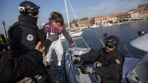 Frontex-Mitarbeiter halten ein Kind nach einer Rettungsoperation in der Nähe von Lesbos, Griechenland (Hafen von Molyvos), am 8. Dezember 2015. (AP Photo/Santi Palacios - KEYSTONE)