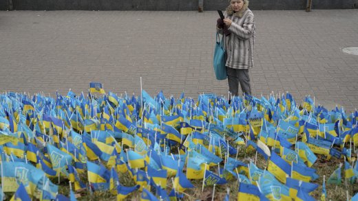Eine Frau fotografiert eine Installation aus ukrainischen Fähnchen zum Gedenken an die getöteten Soldaten. (Bild: Keystone)